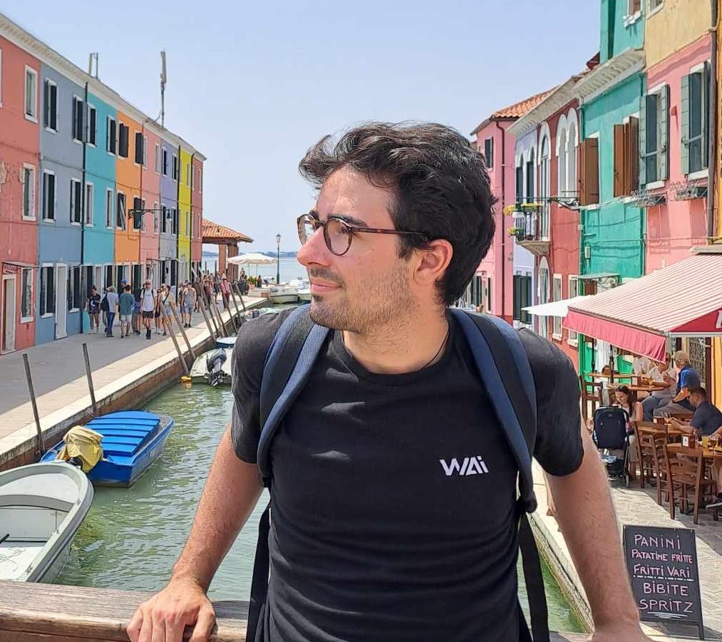 Paul Lezeau standing beside a canal lined with colourful buildings
